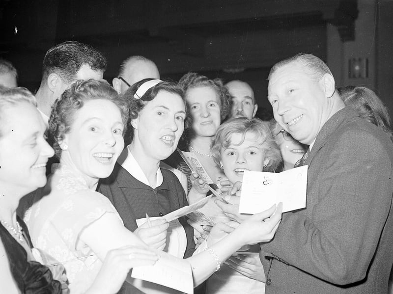 George Formby is swamped by autograph hunters at the Press Ball at the Assembly Rooms, Edinburgh, in October 1956
