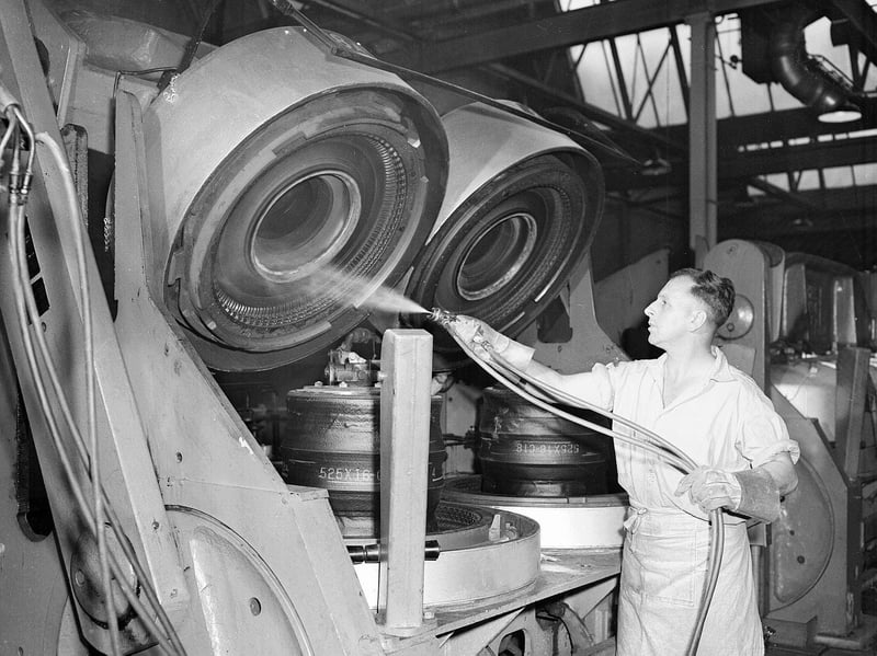 A worker sprays lubricant into tyre moulds at the India Tyre and Rubber Company's factory in Inchinnan, Renfrewshire, in July 1958