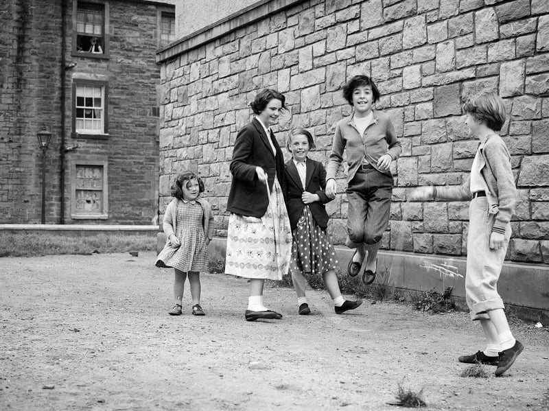 Children playing with a skipping rope on Lapicide Place, Leith, in August 1957