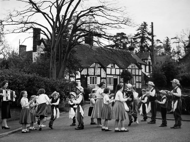 Tong, May 1, 1959. May Day was celebrated in town and country, with these black and white cottages providing an ideal backdrop as local schoolchildren performed the traditional dance.
