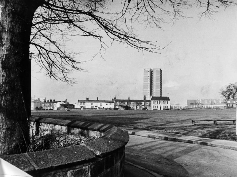 Sheltered by the trees of the village church, and overlooked by towering modern flats, the cottages and village green pictured in November 1967.