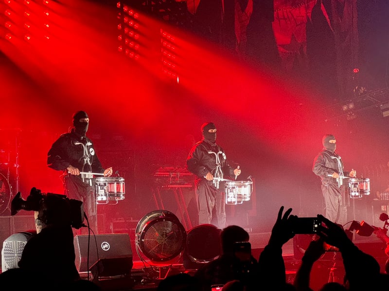 Balaclava-clad drummers take to the stage.