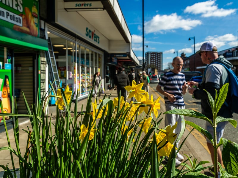 Two locals in conversation as the daffodils bloom on Armley Town Street