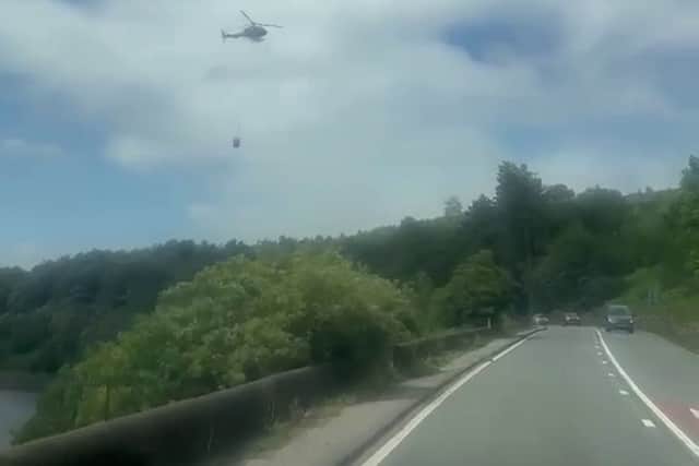 A helicopter is being used by firefighters on the Penniners near Woodhead Pass. Photo: SWNS