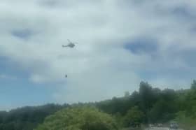 A helicopter is being used by firefighters on the Penniners near Woodhead Pass. Photo: SWNS