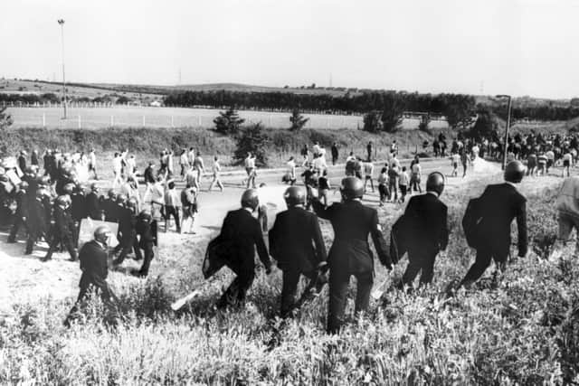 Police escorting picketers away from their position near the Orgreave Coking Plant near Rotherham in 1984 (PA)
