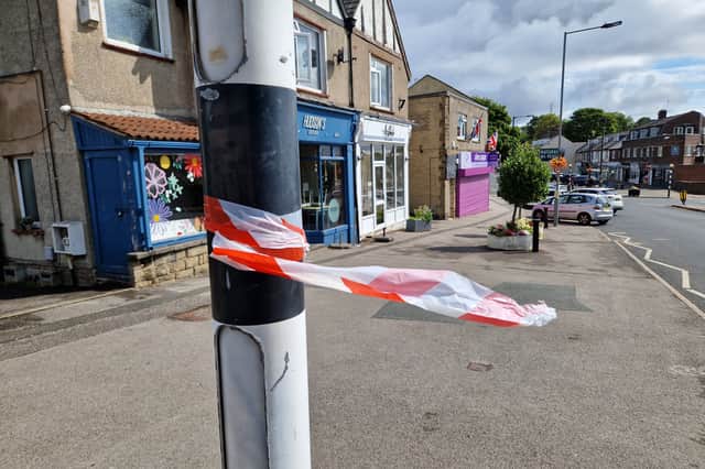 Red and white tape left by the emergency services, near the white frontage of the Aesthete cafe on Sandygate Road, Crosspool, which has been hit by a fire. Photo: Iconic Media
