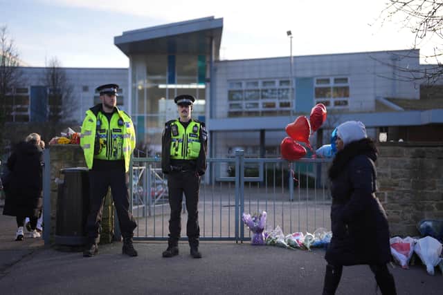 Police officers and floral tributes outside All Saints Catholic High School, on Granville Road in Sheffield (Jacob King/PA)