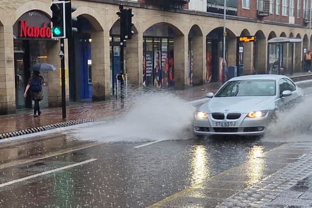 A car ploughs through a deep puddle on West Street, Sheffield. Photo: Iconic Media