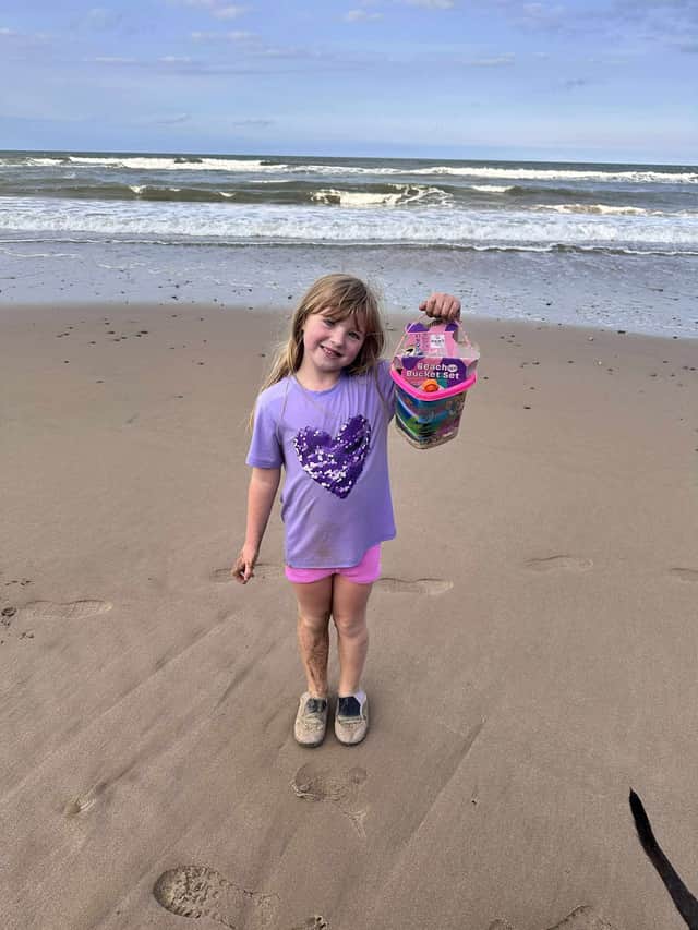 Darcy at the beach with a bucket full of litter, as part of her mission to help save the planet. 