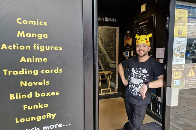 Dan Liles mans the door at Forbidden Planet in a Pikachu hat. Fans queued at the shop on The Moor, Sheffield, for a Pokemon anniversary card drop. Photo: David Kessen, Iconic Media