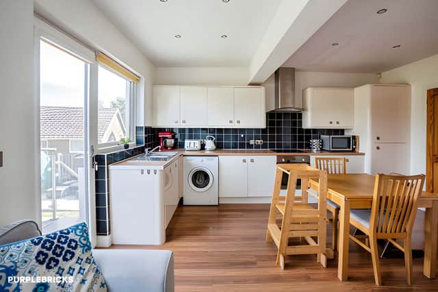 The generously proportioned kitchen provides plenty of room for cooking and family dining, with a balcony opening from the space