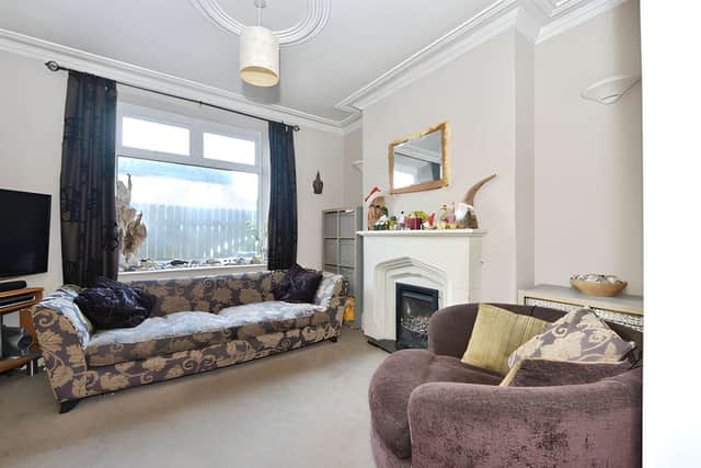 The welcoming lounge features a charming fireplace and double doors connecting it with the fitted kitchen