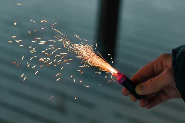 File picture shows someone holding a lit firework. Photo: InfinitumProdux - stock.adobe.com