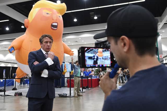 British comedian and political commentator Jonathan Pie reports from beside the 'Baby Trump' balloon at the 2018 Politicon in Los Angeles, California on October 20, 2018. - The two day event covers all things political with dozens of high profile political figures.