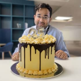 Great British Bake Off winner Dr Rahul Mandal with his showstopper - the official AMRC  25th birthday cake.