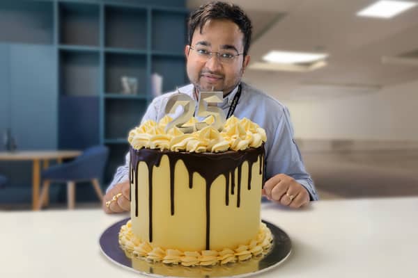Great British Bake Off winner Dr Rahul Mandal with his showstopper - the official AMRC  25th birthday cake.