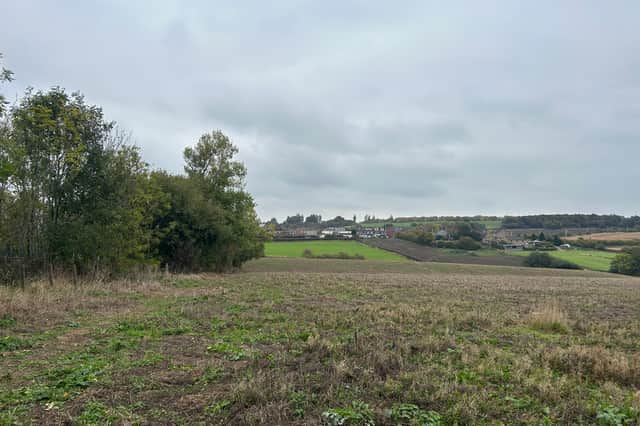 The tree line (left) separates the field from the primary school and children's services