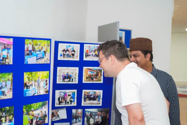 Viewing an exhibition showcasing the community’s environmental, humanitarian, and charitable activities.
