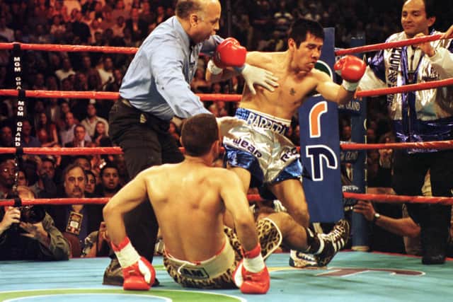 Naseem Hamed is pulled off of Marco Antonio Barrera by referee Joe Cortez during their bout at the MGM Grand Garden Arena in Las Vegas, Nevada. Mandatory Credit: John Gichigi/ALLSPORT
