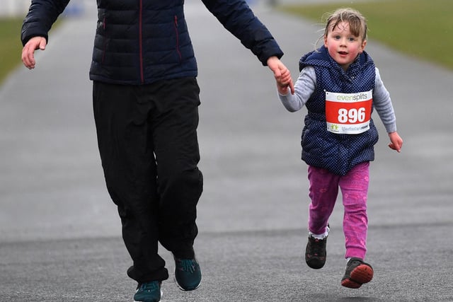 A young runner is given a helping hand around the fun run route.