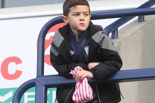 A young Preston fan is armed with an old fashioned sweet bag as he looks out onto Deepdale.