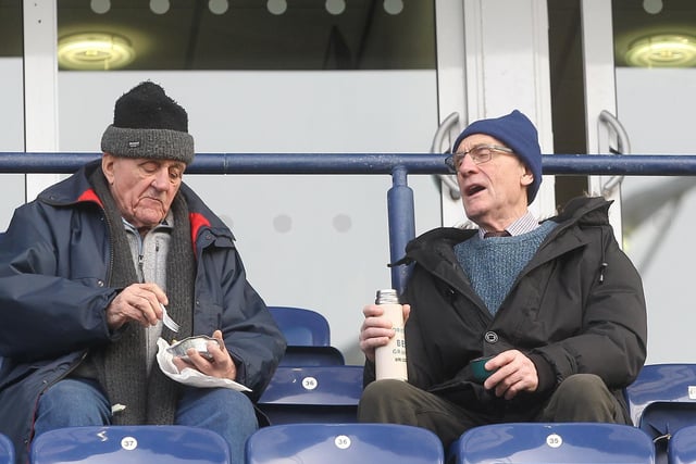 A great combination for these two PNE fans, one tucks into a pie whilst the other drinks from his flask.