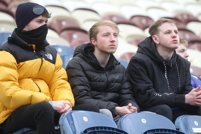 Three PNE fans look out towards the pitch before the game on Saturday.