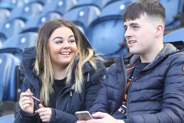 A pair of Preston fans keep themselves busy pre-game.