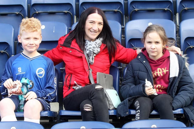 Three Preston fans pose and give a smile for our cameraman as they sit ready for the game.