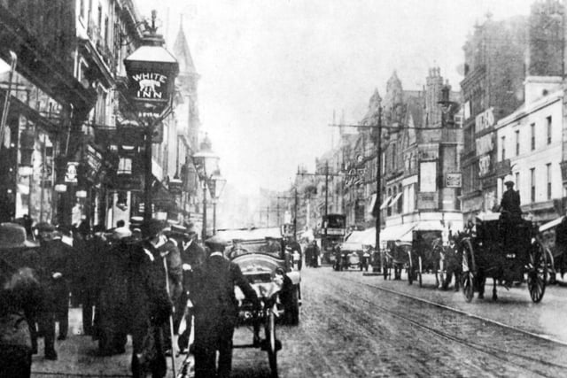 Briggate looking towards the junction of Upperhead Row and Lowerhead Row, which since the 1930s has been known as The Headrow. A sign for the White Bear Inn can be seen on a lamp.