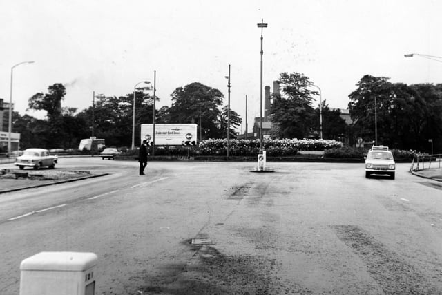 A pedestrian negotiates Stanningley Road at Bramley Town End at the point of a vanished zebra crossing.