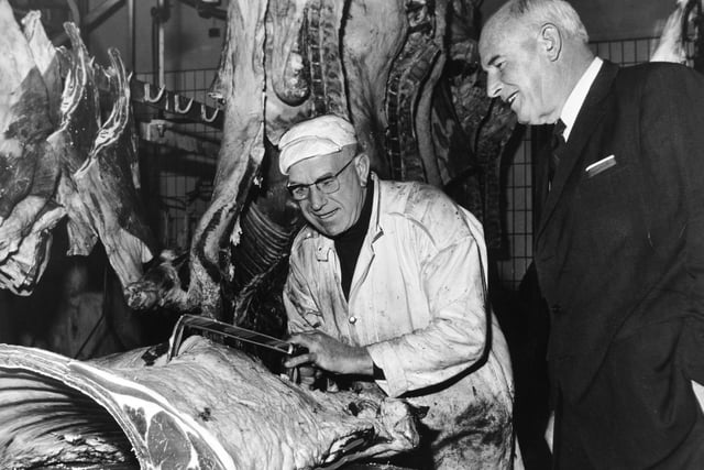 New Zealand diplomat Sir Dennis Blundell talks with Jack Wright during his tour of the Leeds Wholesale Meat Market and Abattoir. Mr Wright was cutting a fore quarter of beef.