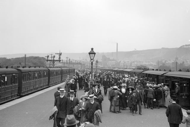 In 1913 crowds of day-trippers and holidaymakers arrive on a platform at Scarborough railway station.