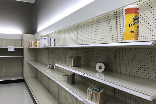 Nearly empty shelves, that usually hold toilet paper, facial tissue and paper towels, are viewed in a Target store in Olympia, Washington.