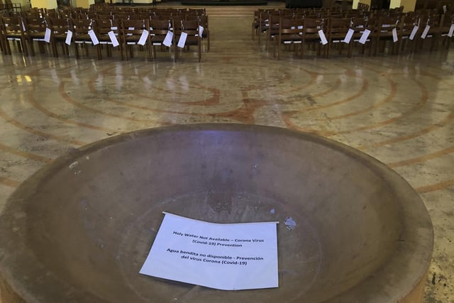 A sign reads, "Holy Water Not Available" in the baptismal font of the St. Stephen and the Incarnation Episcopal Church in Washington.