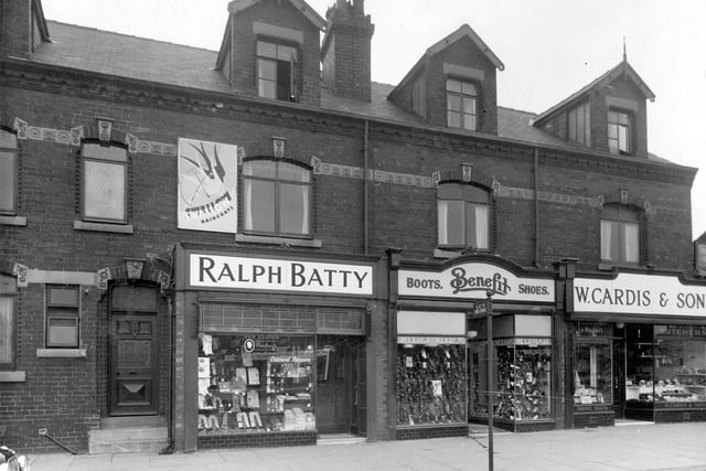 Station Road at the end of the 1930s. Pictured is men's outfitters Ralph Batty, the Benefit Boot and Shoe company shop and William Cardis and Sons butchers. The poster for Swallow raincoats was put up without planning permission.