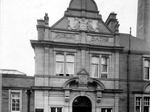 Bramley Public Baths, located on the junction of Broad Lane and Calverley Lane. It was one of many public baths and swimming pools built in Leeds around the late 1890s and early 1900s. A board with admission charges is on the left.