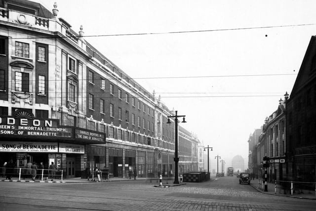 The Headrow, looking east from the junction with Briggate towards Eastgate. Prominent in the photo is The Odeon cinema, which is showing "The Song Of Bernadette".