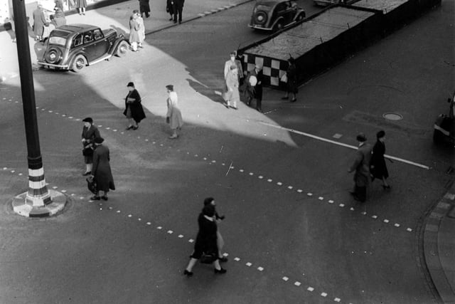 Pedestrians crossing The Headrow near Lewis's department store.