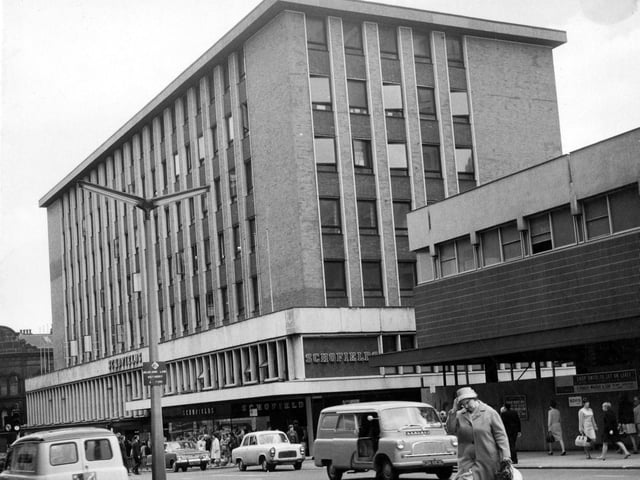 Schofields main building in 1967. This was completed in 1962. Now replaced by the Headrow Shopping Centre. There are cars and vans on the street. People are on the pavement and crossing the road.