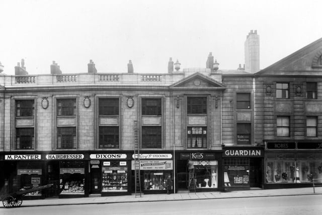 The south side of The Headrow. Businesses include M. Panter, hairdresser; J.R. Dixon and Sons, tobacconist; Kays Hosiery; H. Krebs, furrier; West Leeds News Ltd, publishers, and Lucette (Leeds) Ltd, gowns.