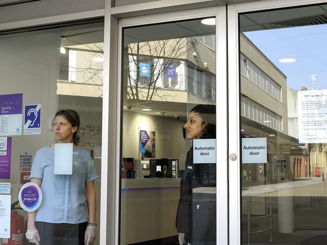 Staff at Skipton Building Society look out at the empty street.