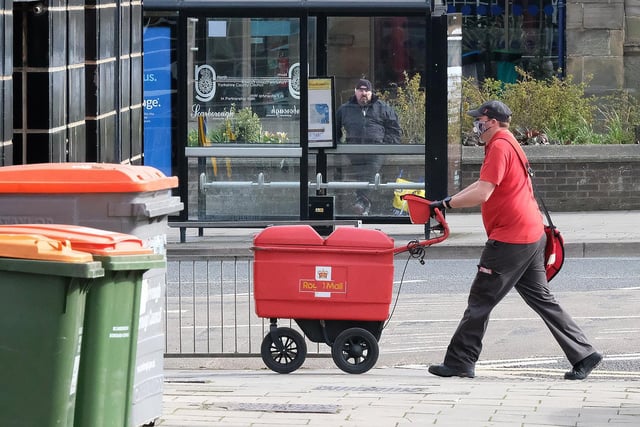 A Royal Mail employee wears a mask while delivering post.