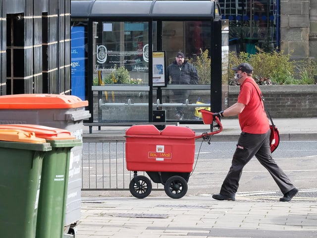 A Royal Mail employee wears a mask while delivering post.