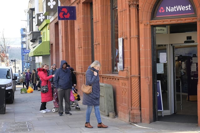 People observe social distancing while queuing for NatWest.