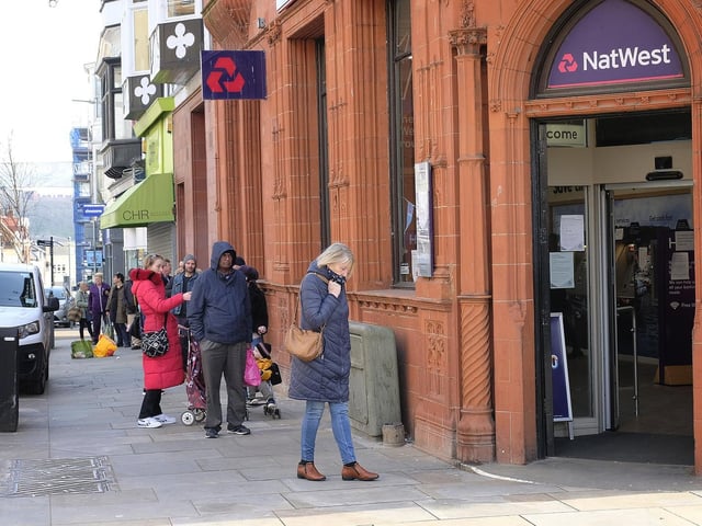 People observe social distancing while queuing for NatWest.