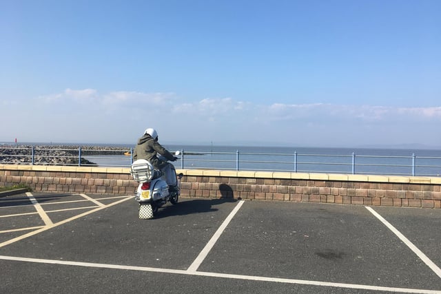 A lone motorcyclist looks out over the bay