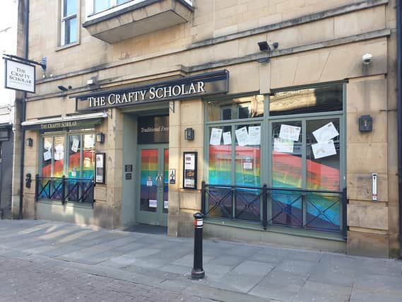 A display of rainbows and children's messages in the windows of The Crafty Scholar in Church Street.