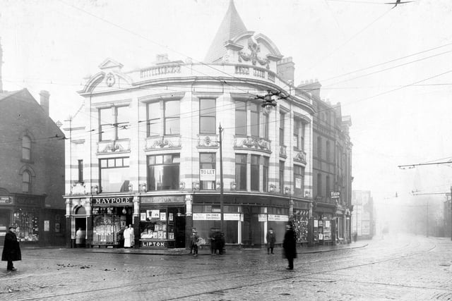 Hyde Park corner at the junction of Headingley Lane and Hyde Park Road. Maypole Dairy Co. can be seen with two shop keepers in the Doorway. Next door is Lipton grocers, known then as provision dealers.